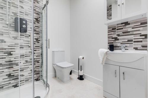 a bathroom with a shower and a toilet and a sink at We Stay Baxter Gate in Loughborough