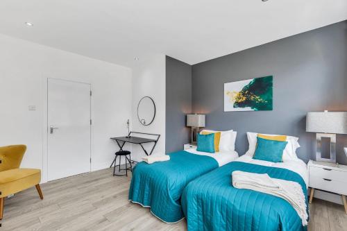a bedroom with two beds with blue sheets at We Stay Baxter Gate in Loughborough