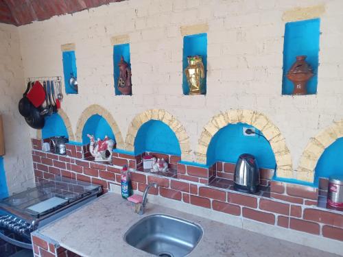 cocina con fregadero y pared de ladrillo en A R A B I A Golden Palace en Luxor