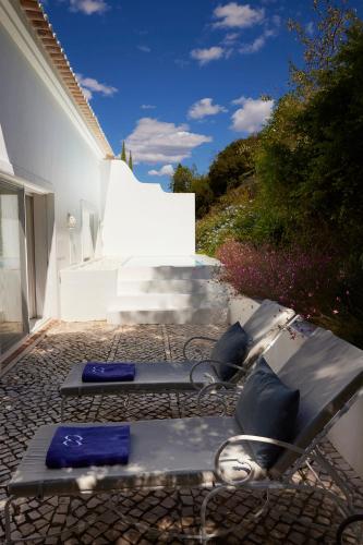 a patio with two lounge chairs on the side of a house at Octant Vila Monte in Moncarapacho