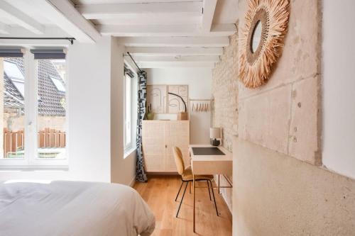 een slaapkamer met een bed en een bureau met een stoel bij Le Matilda - Appt Hypercentre 2 pers in Caen