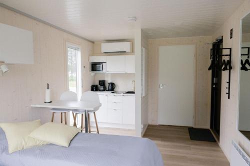 a bedroom with a bed and a table and a kitchen at Hotel OmaBox - Nivala - Oma huoneisto saunalla in Nivala