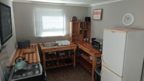 a kitchen with a refrigerator and a table and a stove at 11 Mountain Stream Hot Tub Self Catering in Gordonʼs Bay