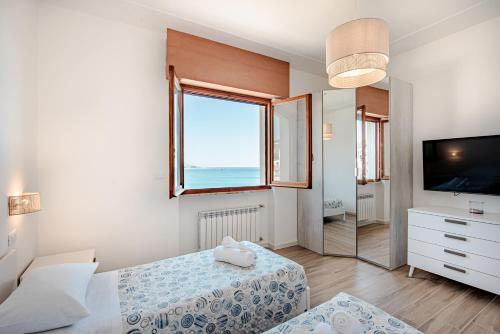 a bedroom with a bed and a television and a window at You and the Sea in Savona