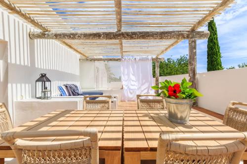 a table and chairs on a patio with a pergola at Octant Vila Monte in Moncarapacho