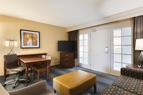 a hotel room with a desk and a television at Embassy Suites by Hilton Bloomington/Minneapolis in Bloomington