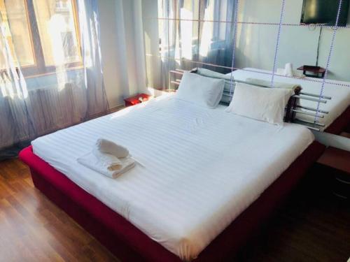 a large white bed with a hat on top of it at Joy City Stay Republicii 19 in Timişoara