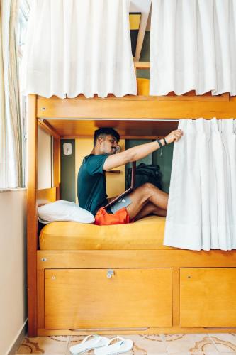 a man sitting on top of a bunk bed at Discovery Hostel in Rio de Janeiro