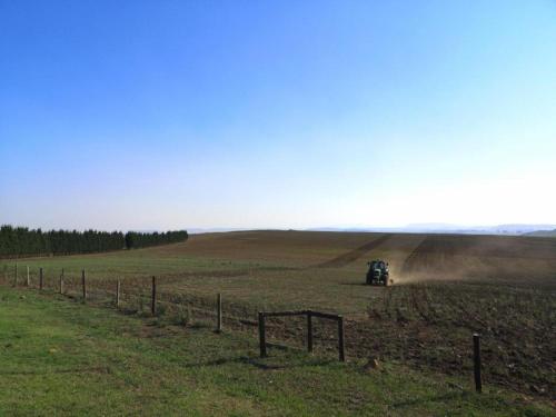 un tracteur dans un champ avec clôture dans l'établissement Hythe Cottages, à Mooirivier