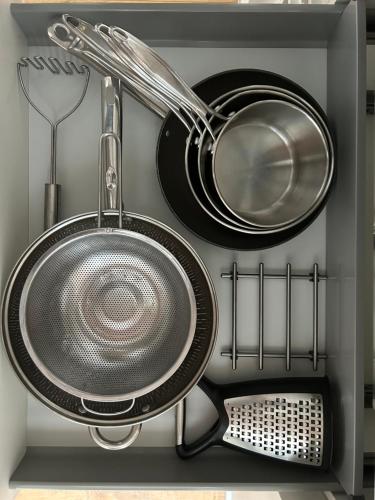 a shelf with pots and pans and other kitchen utensils at Central and Quirky Northern Quarter Flat, Manchester in Manchester