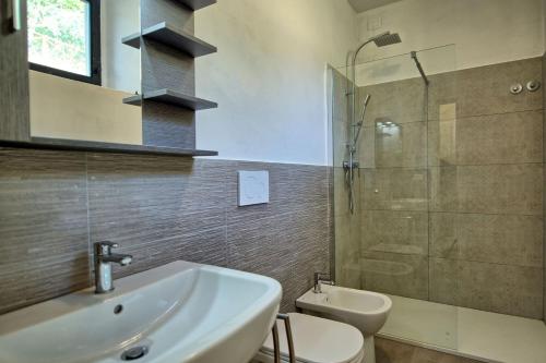 uma casa de banho com um lavatório, um WC e uma cabina de duche em vidro. em Querciolaia by PosarelliVillas em Pieve a Presciano