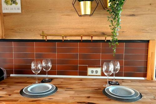 a table with two plates and wine glasses on it at Mogosoaia High Living Penthouse in Chitila