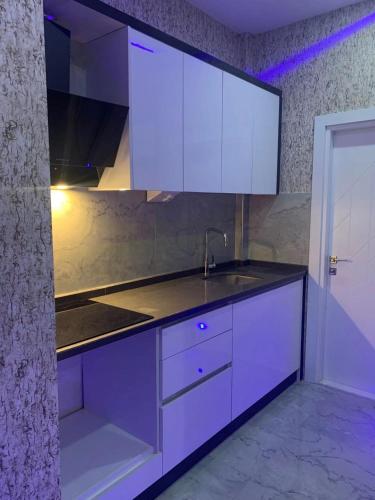 a kitchen with white cabinets and a sink at Antalya centre in Antalya