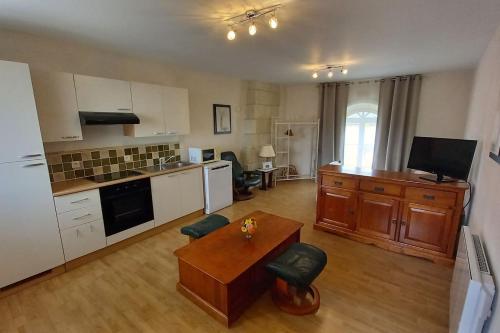 a kitchen with white cabinets and a wooden table at Gîte Angevin 2 à 4 personnes in Montreuil-Bellay