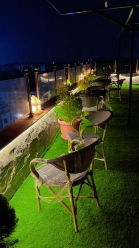 a row of chairs on a patio at night at Pyramids Tower view inn in Nazlat as Sammān
