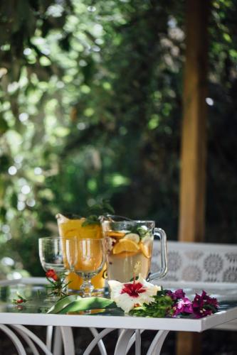 a table with two glasses of tea and flowers on it at Octant Vila Monte in Moncarapacho