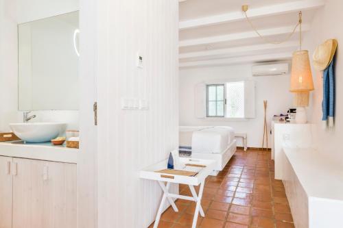 a white kitchen with a sink and a table at Octant Vila Monte in Moncarapacho