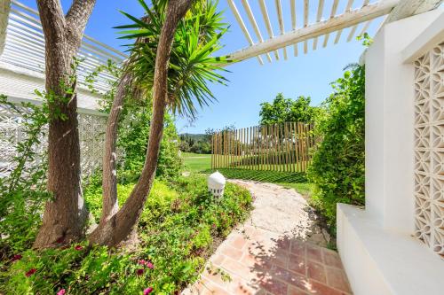 a garden with a palm tree and a walkway at Octant Vila Monte in Moncarapacho