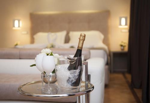 butelkę szampana i kieliszki na stole w pokoju hotelowym w obiekcie Terrazza Marco Antonio Luxury Suite w Rzymie