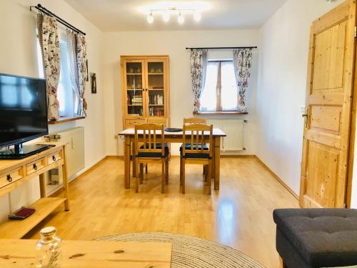 a living room with a table and chairs and a television at Haus Gerda Ferienwohnung 2 in Arnbruck