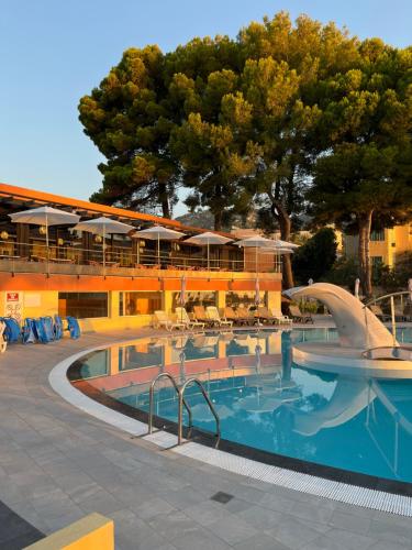 a swimming pool with a slide in front of a resort at Hôtel Vacances Bleues Delcloy in Saint-Jean-Cap-Ferrat