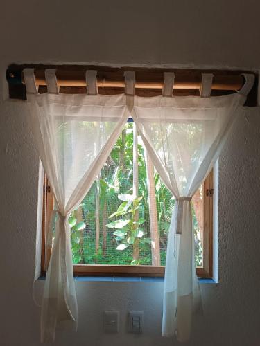 a window with white curtains in a room at jungle lodge in Cancún