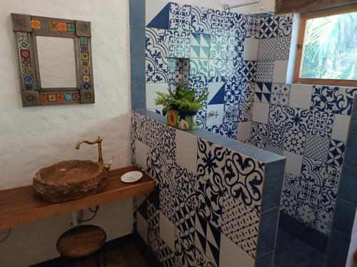 Łazienka wyposażona jest w umywalkę oraz niebiesko-białe kafelki. w obiekcie jungle lodge w mieście Cancún