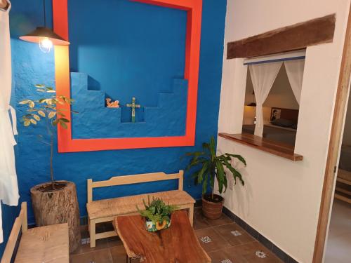 uma sala de estar com uma mesa e uma parede azul em jungle lodge em Cancún