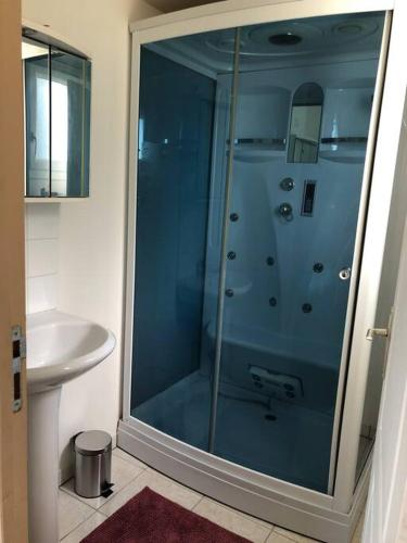 une salle de bain avec une douche en verre et un lavabo dans l'établissement Maison familiale à 1km de la mer, à Blainville-sur-Mer