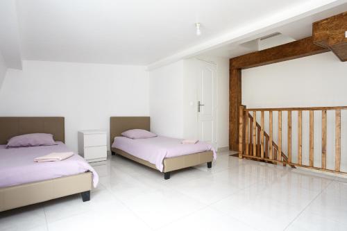 a bedroom with two beds and a staircase at Le blanc 23D 1ère ETG F2 duplex face gauche in Le Blanc-Mesnil