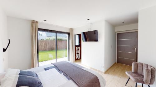 une chambre avec un lit et une porte coulissante en verre dans l'établissement VILLA OCEAN ZEN, à Combrit