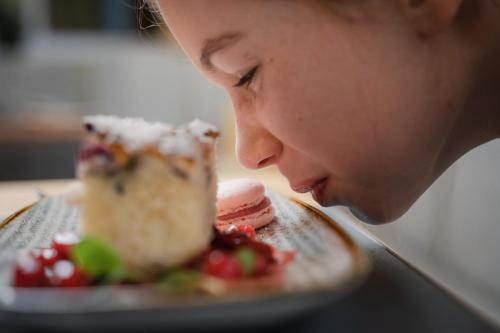a woman is looking at a plate of cake at Dilly - Das Nationalpark Resort in Windischgarsten