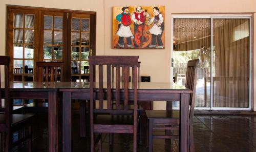a dining room with a table and a painting on the wall at Zoete Rust Boutique Hotel in Lephalale