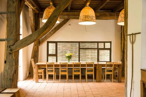 Viscri 125 في فيسكري: غرفة طعام مع طاولة وكراسي خشبية