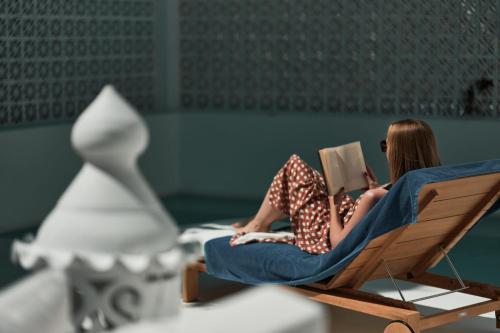 two girls sitting in a chair reading a book at Octant Vila Monte in Moncarapacho