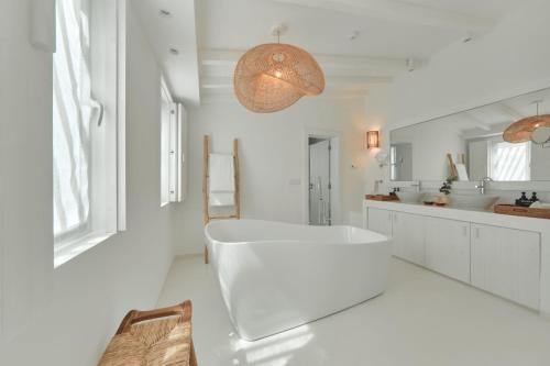 a white bathroom with a tub and two sinks at Octant Vila Monte in Moncarapacho