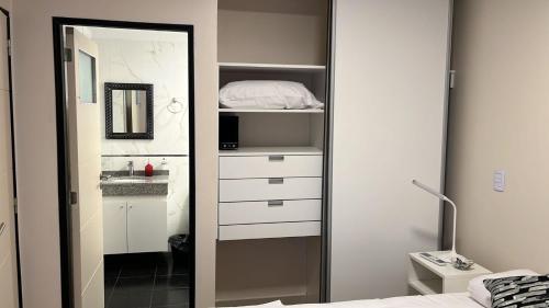 een slaapkamer met een spiegel, een bed en een wastafel bij Apart26 C425 Dpto hermoso en Tucumán in San Miguel de Tucumán