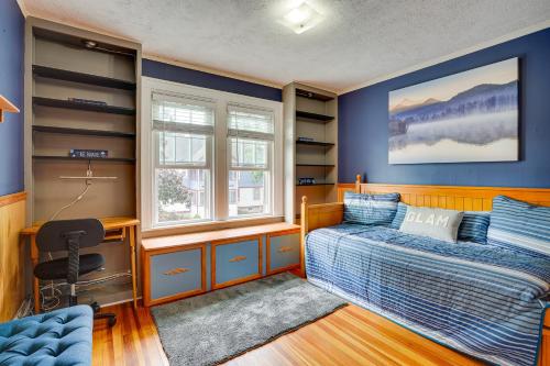a bedroom with blue walls and a bed and a desk at Utica Vacation Rental Gas Grill and Spacious Yard! in Utica