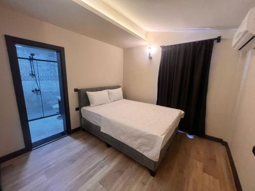 a small bedroom with a bed and a window at Hayal Fener in Antalya