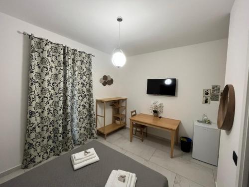 a living room with a bed and a table and a television at La Pineta nel Borgo in Ravenna