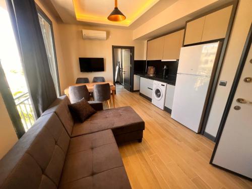 a living room with a couch and a kitchen at Hayal Fener in Antalya