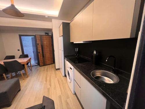 a kitchen with a sink and a table in a room at Hayal Fener in Antalya