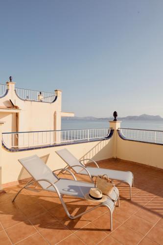 a balcony with a chair and a table and the ocean at JS Horitzó in Can Picafort