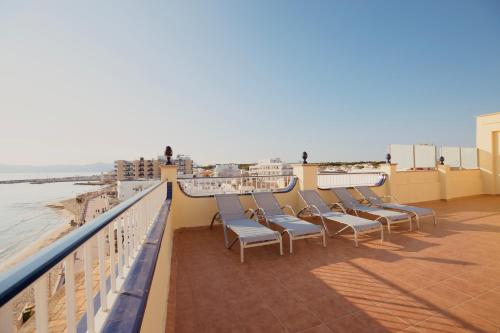 a row of chairs sitting on a balcony overlooking the ocean at JS Horitzó in Can Picafort