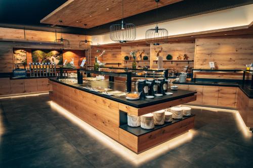 a restaurant with a counter with dishes on it at Dilly - Das Nationalpark Resort in Windischgarsten