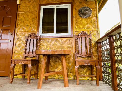 a house with two chairs and a window at Jazz Ferme Inn Batuan Bohol in Batuan