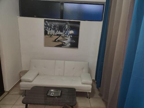 a living room with a white couch and a table at Full size 2 bedrooom 2 bath condo split in Sosúa