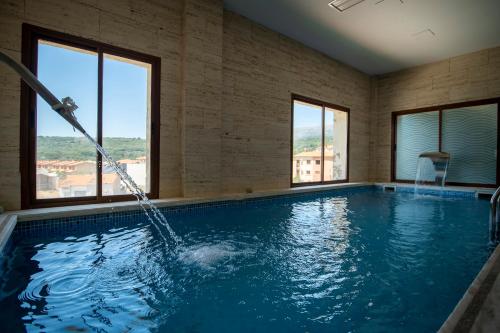 basen z wężem wodnym w pokoju z oknami w obiekcie Hotel Rural Spa Don Juan de Austria w mieście Jarandilla de la Vera