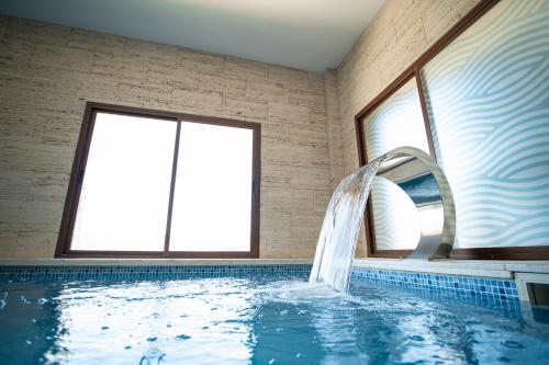 a bathroom with a swimming pool with a water fountain at Hotel Rural Spa Don Juan de Austria in Jarandilla de la Vera