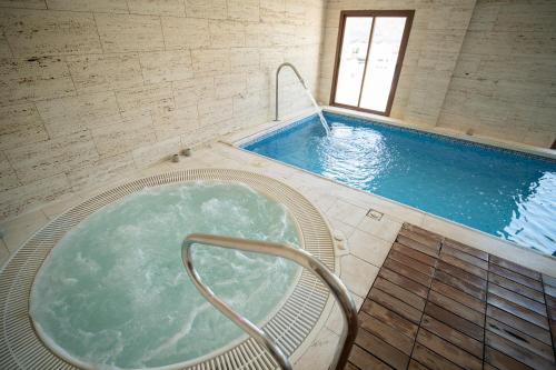 duży basen z jacuzzi w budynku w obiekcie Hotel Rural Spa Don Juan de Austria w mieście Jarandilla de la Vera